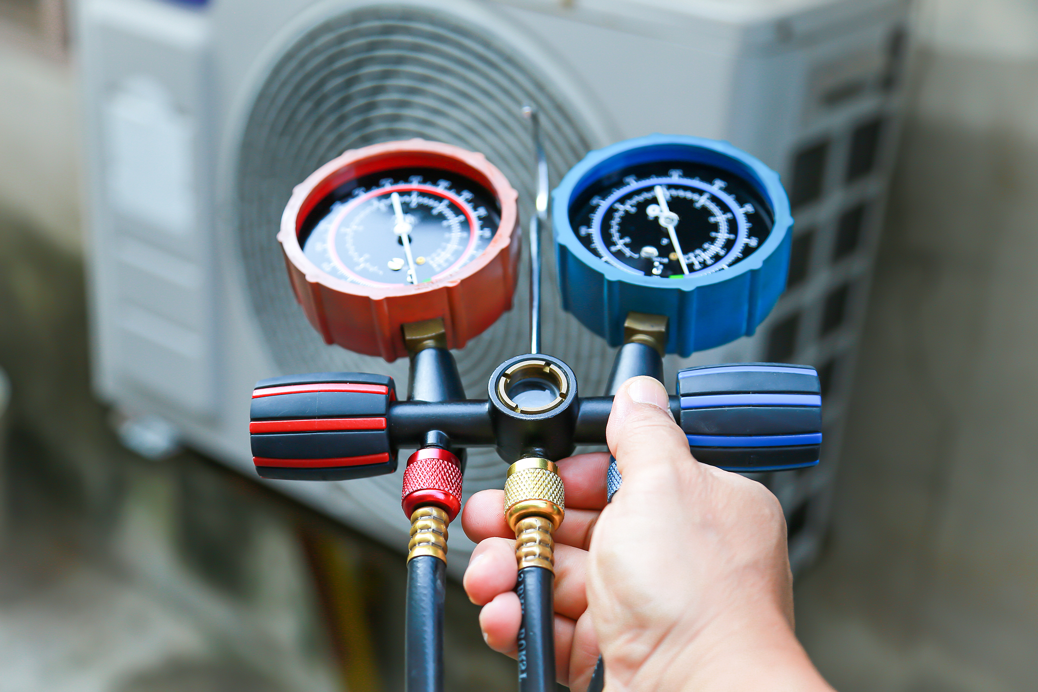 Technician checking air conditioning operation, detecting refrigerant leaks.